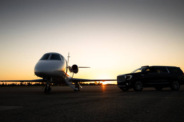 A black luxury parked in front of a private jet during sunset. Dane County Airport Car Service